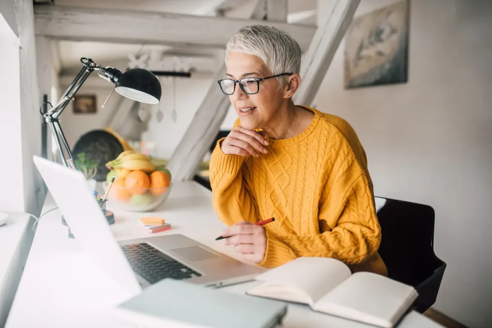Older Woman with Computer and Open Books